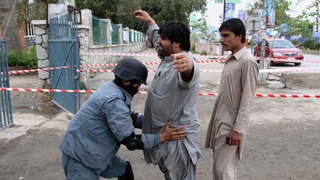 A police officer checks a man at a polling station in Jalalabad.