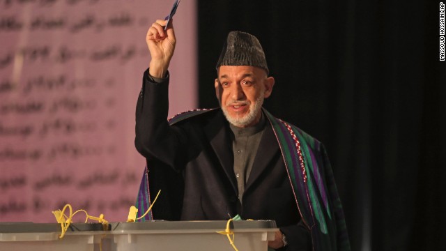 President Hamid Karzai shows his ballot to the media before he casts his vote at Amani High School, near the presidential palace in Kabul.