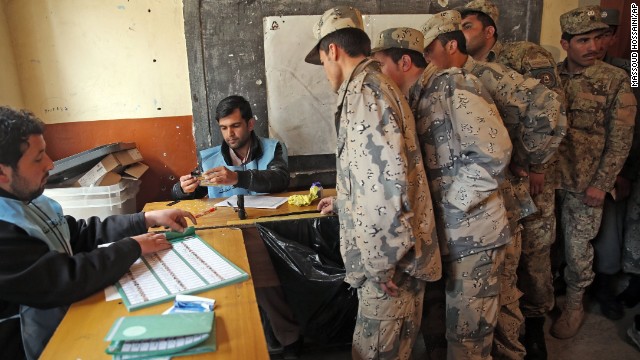 Afghan security personnel line up for registration before voting at a polling station in Kabul.