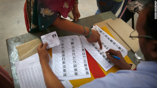 A woman points out her photo before casting her vote in New Delhi on April 10. There are 814 million eligible voters in India, making this the largest election in world history.