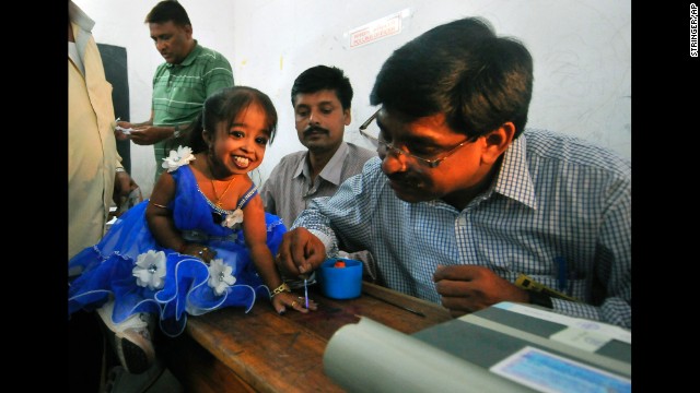 Jyoti Amge, a first-time voter and the world's shortest woman according to Guinness World Records, gets her finger marked with ink after voting in Nagpur, India, on April 10.