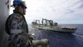 This handout photo taken on April 7, 2014 and released on April 9, 2014 by Australian Defence shows Maritime Warfare Officer, Sub Lieutenant Ryan Penrose watching HMAS Success as HMAS Perth approaches for a replenishment at sea while searching for missing Malaysia Airlines flight MH370 in the southern Indian Ocean. Two fresh signals have been picked up Australian ship Ocean Shield in the search for missing Malaysian flight MH370, raising hopes that wreckage will be found within days even as black box batteries start to expire. 