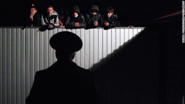 Pro-Russian young men look over the fence of a military recruitment office in Donetsk on Thursday, April 10.