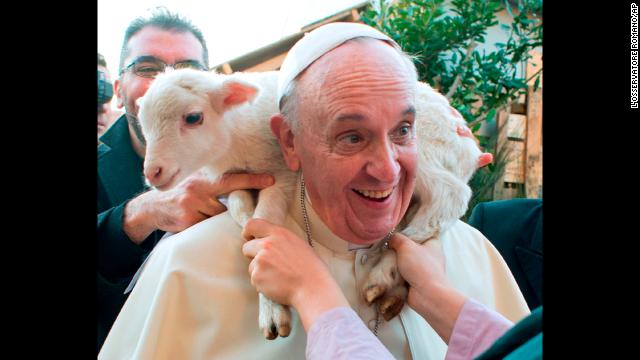 A lamb is placed around Francis' neck as he visits a living nativity scene staged at the St. Alfonso Maria de' Liguori parish church, on the outskirts of Rome, on January 6.