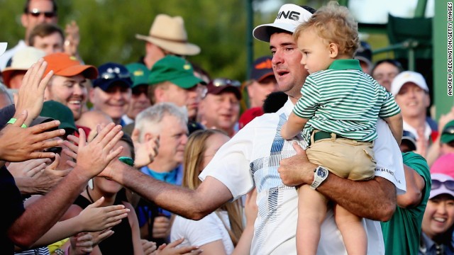 An emotional Watson holds his son, Caleb, as he celebrates with fans by the 18th green at Augusta.