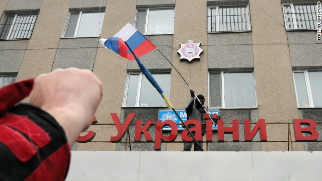 A man places a Russian flag over a police station after storming the building in Horlivka on April 14.