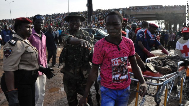 A man is directed by rescue workers as they collect the bodies of victims on April 14. 