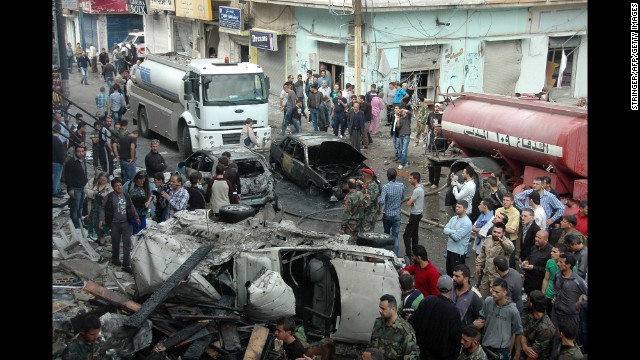 Security and emergency medical personnel work at the site of a car bomb explosion Monday, April 14, in the Ekremah neighborhood of Homs. 