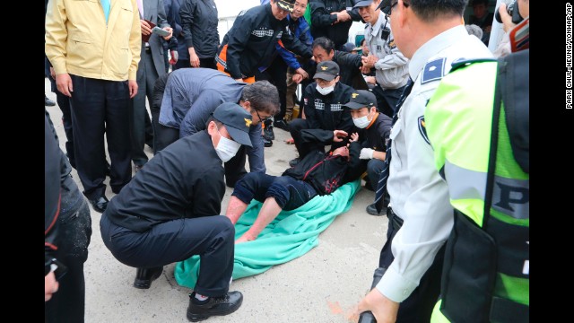 Police and rescue teams carry a passenger at the port in Jindo on April 16. 