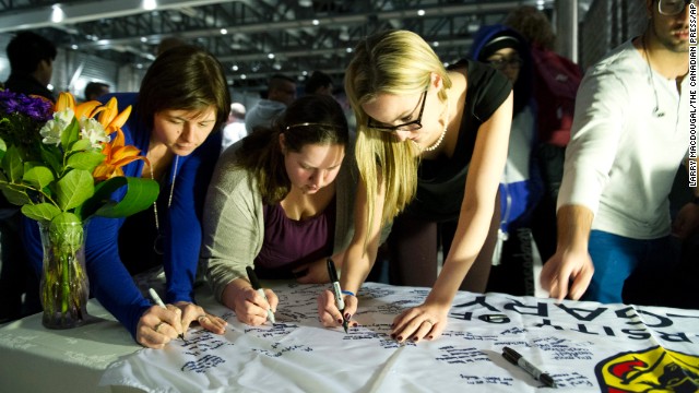 University of Calgary students and staff sign condolences on a banner during a memorial service for victims.