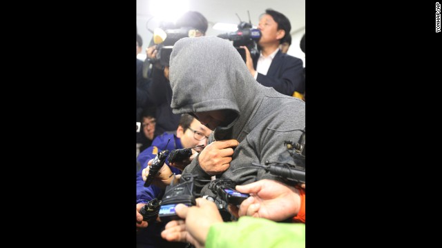 The ship's captain, Lee Joon Suk, arrives at the Mokpo Police Station in Mokpo on April 17. His head and face covered, he broke down in tears when reporters asked whether he had anything to say.