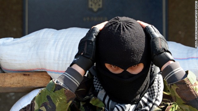 A masked man stands guard outside a regional administration building seized by pro-Russian separatists in Slavyansk on Friday, April 18. 