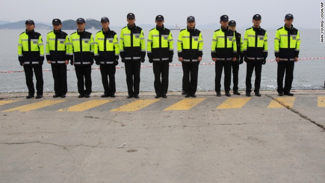 Police officers stand guard Saturday, April 19, at the port in Jindo to prevent relatives of the ferry's missing passengers from jumping in the water. Some relatives have said they will swim to the shipwreck site and find their missing family members by themselves.