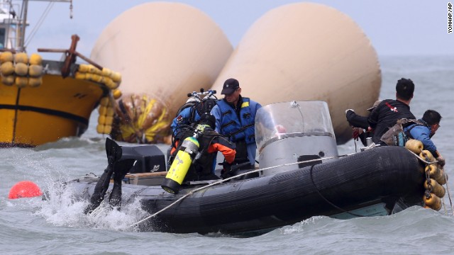 Divers jump into the water on April 21 to search for passengers near the buoys that mark the site of the sunken ferry.