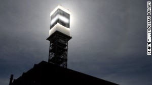 Sunlight from mirrors is reflected onto a solar receiver and boiler. Water is heated to produce steam to power turbines.