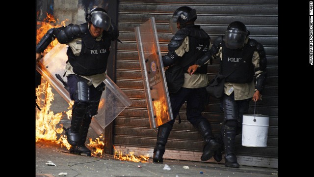 A police officer runs from a fire set off by a Molotov cocktail thrown by protesters in Caracas on April 17.