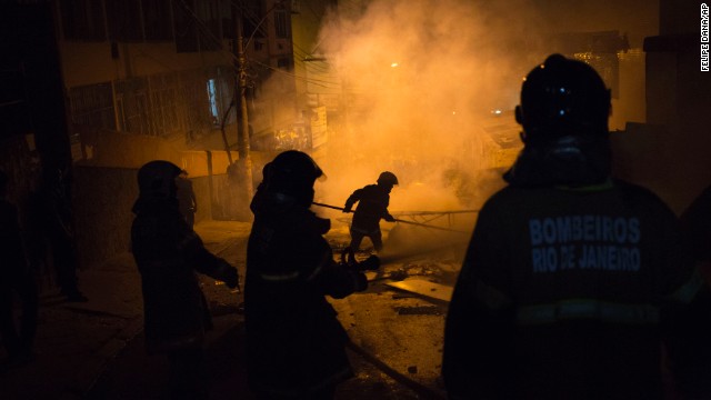 Firefighters put out a burning barricade during clashes.