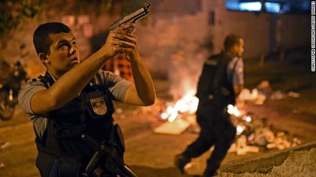 A police officer points his weapon during the protests.