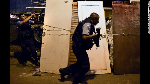 Police officers take positions during clashes with protesters.