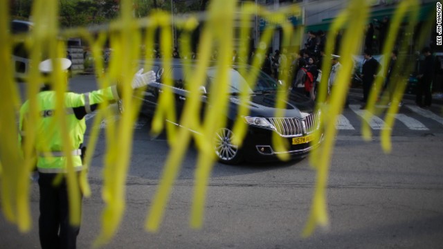 Yellow ribbons honoring the victims flap in the wind as a hearse carrying a victim's body leaves Danwon High School in Ansan on April 24. Most of the people on board the ferry were high school students on their way to the resort island of Jeju.