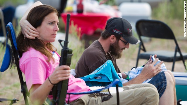 Chris Shelton of Las Vegas interacts with his 1-week-old son as his mother Shelley Shelton holds his rifle during a Bundy family "Patriot Party" near Bunkerville, Nevada, on April 18.