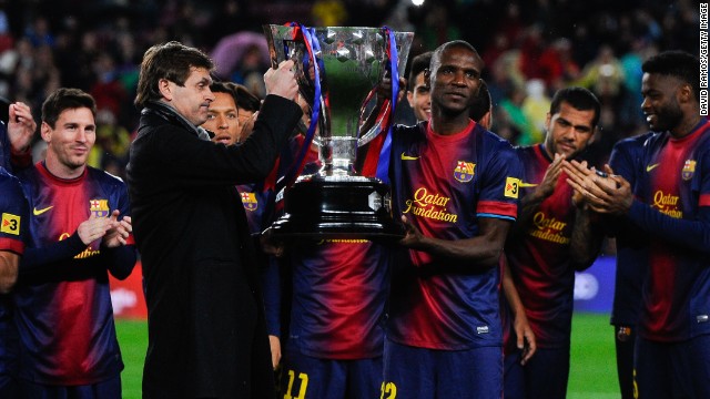 Vilanova and Eric Abidal, who had been diagnosed with a liver tumor, share the honors as they lift the trophy for Barca's 22nd league title.