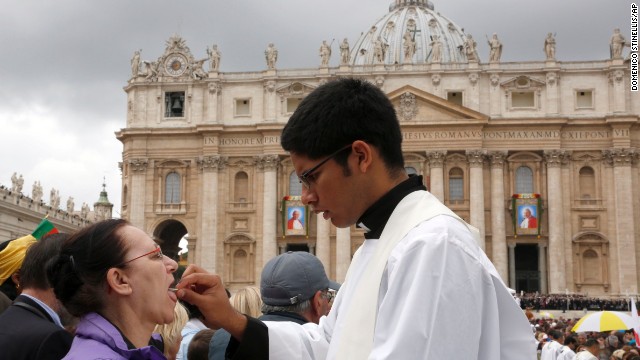 A priest gives Holy Communion to a woman in St. Peter's Square at the Vatican on April 27.