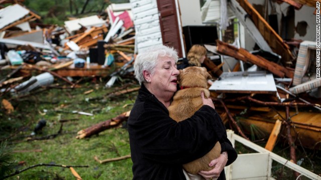 Constance Lambert embraces her dog after finding it when she returned to her destroyed home in Tupelo on Monday, April 28.