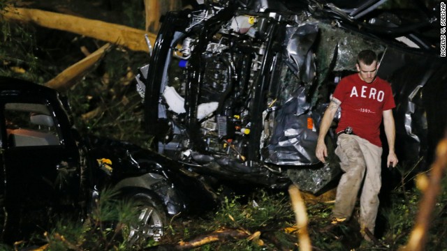 A searcher walks past the remains of an SUV in Louisville, Mississippi, early Tuesday, April 29, after a tornado hit the community in the eastern part of the state. Eight people died in Mississippi on Monday, the state emergency management office said. 