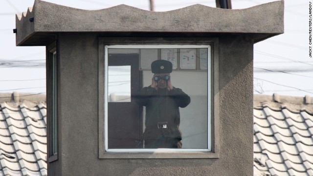 A soldier looks through binoculars inside a sentry post along the bank of the Yalu River on Monday, April 7.