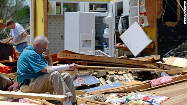Charles Milam takes a break while searching his destroyed home in Tupelo on April 29.