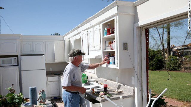 Jerry Estes salvages food items April 30 from the kitchen of his home that was damaged by a tornado in Louisville.