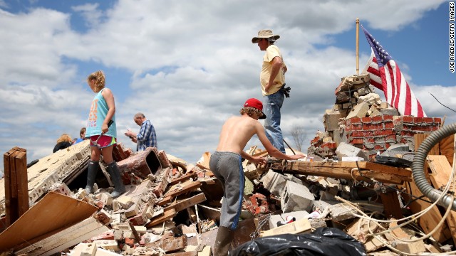 People look for items to salvage from a relative's tornado-ravaged home in Louisville, Mississippi, on Wednesday, April 30. 