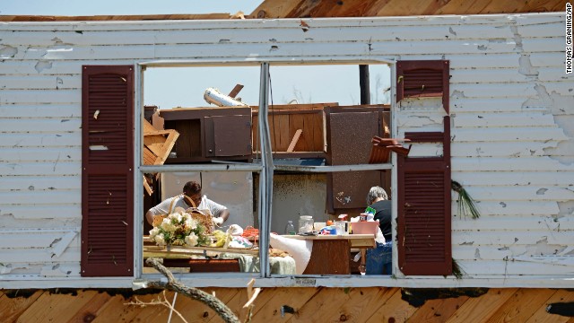Bobbi Leggon and Sudie Carter work to salvage items from a friend's home in Tupelo on April 29.