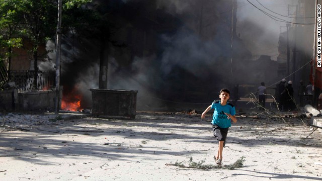 A boy runs in Aleppo on Sunday, April 27, after what activists said were explosive barrels thrown by forces loyal to al-Assad.