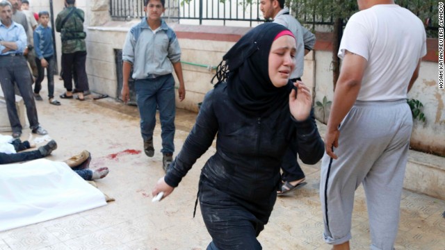 A woman runs after two barrel bombs were thrown, reportedly by forces loyal to Syrian President Bashar al-Assad in Aleppo on May 1.