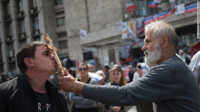 An Orthodox priest, in front of the administration building in Donetsk, blesses a pro-Russian activist May 4 as people gather to honor the memory of fallen comrades in Odessa.