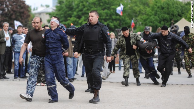 Pro-Russian supporters lead blindfolded men in front of the regional administration building in Donetsk on Monday, May 5.