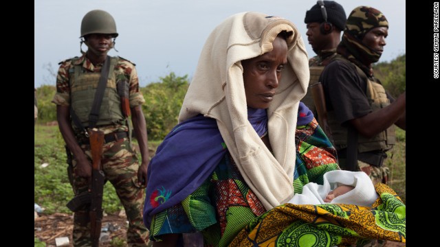 A woman holds one of the newborn babies near Kaga Bandoro as the convoy prepares to leave on April 29.