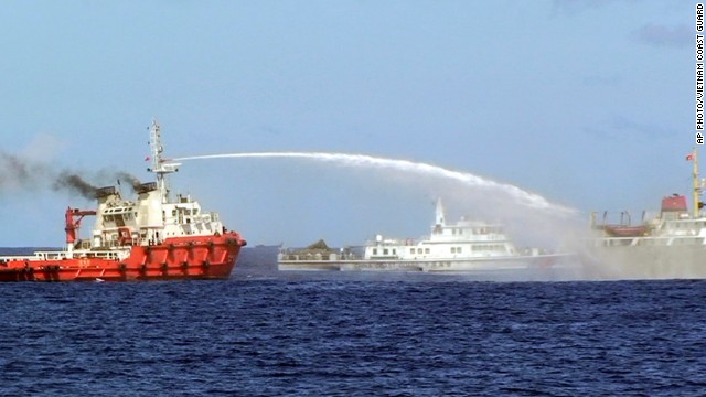 In this photo released by the Vietnam Coast Guard, a Chinese ship, left, shoots water cannon at a Vietnamese vessel, right, while a Chinese Coast Guard ship, center, sails alongside in the South China Sea, off Vietnam's coast, Wednesday, May 7, 2014.