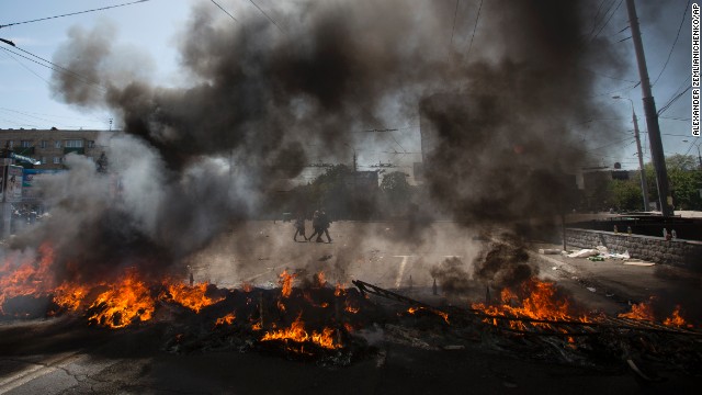 Black smoke billows from burning tires used to prevent government troops' armored personnel carriers from passing through in Mariupol, Ukraine, on Saturday, May 10. 