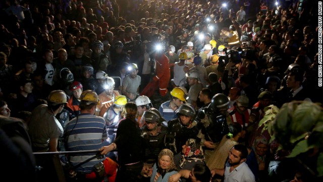 A massive crowd watches as rescuers work into the night.