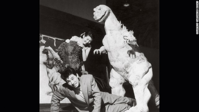 "Godzilla" stars Akira Takarada, bottom, and Momoko Kochi clown around at Toshimitsu's fabrication studio with the unfinished monster costume in 1954. 