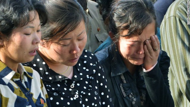 North Korean women listen as the official apologizes. 