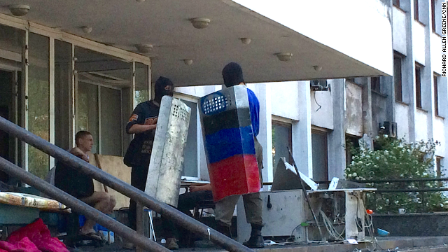 A handful of young men who say they support independence for this region of eastern Ukraine practice with riot shields on the steps of the ruined City Hall.