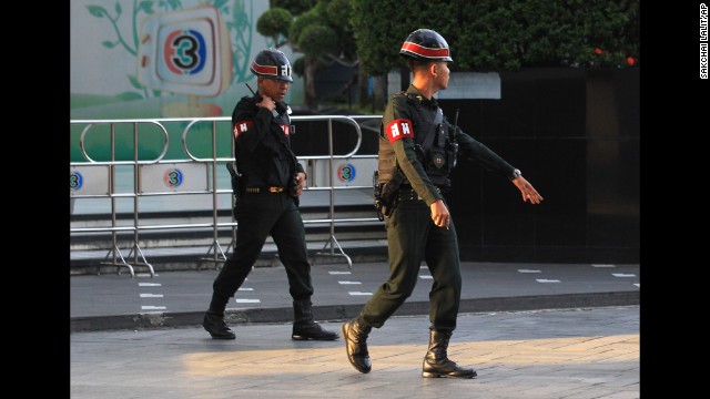 Military police officers walk in front of the Thai TV 3 offices in Bangkok on May 20. In a statement read on Thai television, the military declared that all of the country's radio and television stations must suspend their normal programs "when it is needed."