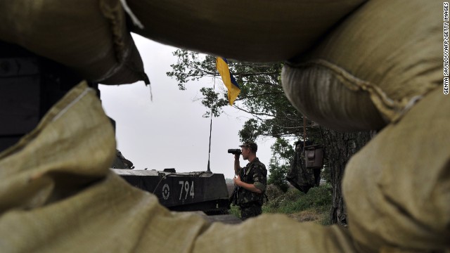 A Ukrainian soldier stands guard on the road from Izyum to Slovyansk on Monday, May 19.