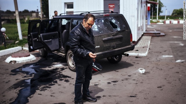 A man looks at a bullet shell next to a destroyed car after a gunfight between pro-Russian militiamen and Ukrainian forces in Karlivka, Ukraine, on Friday, May 23. Tensions remain high across the country's east, where pro-Russian separatists staged referendums on independence earlier this month.