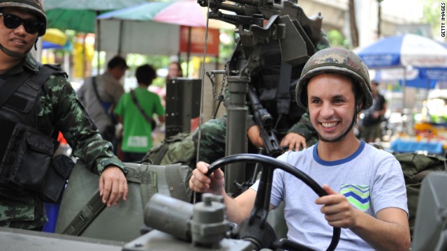 A tourist sits in a Thai army vehicle as soldiers deploy on a downtown street after martial law was declared on Tuesday, May 20.