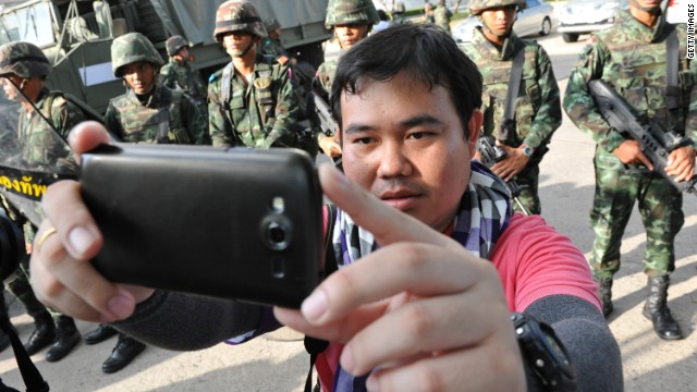 A member of the press takes a selfie with soldiers on May 22 in Bangkok.